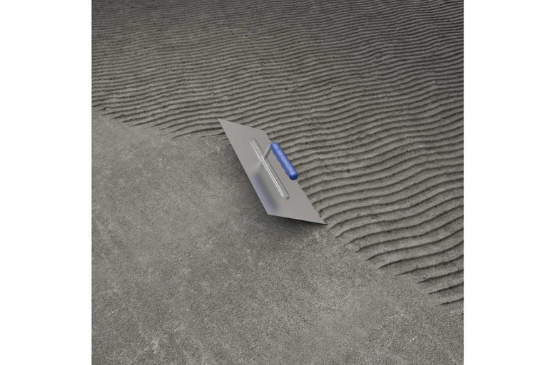 Spatule dentée sur colle à carrelage pour la pose de carrelage