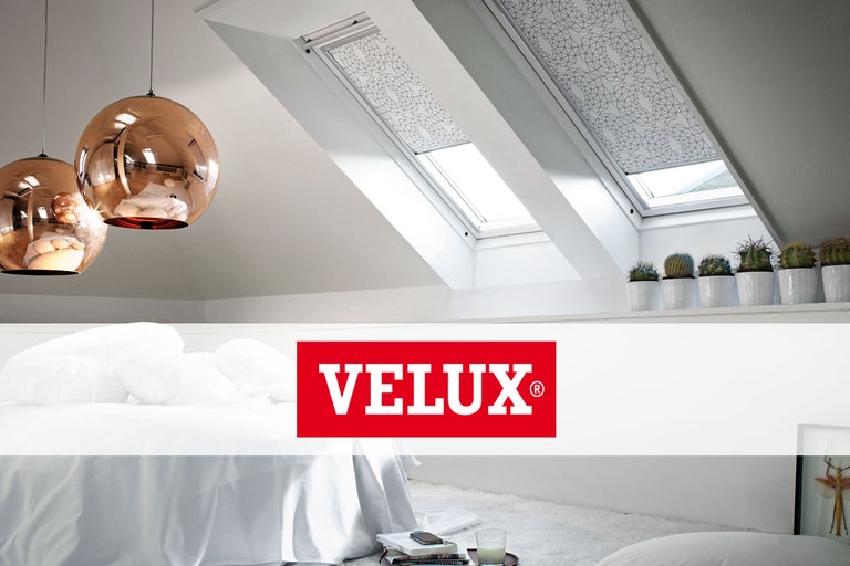 Schlafzimmer mit Dachfenstern und Verdunkelungsrollos, darüber Velux Logo.
