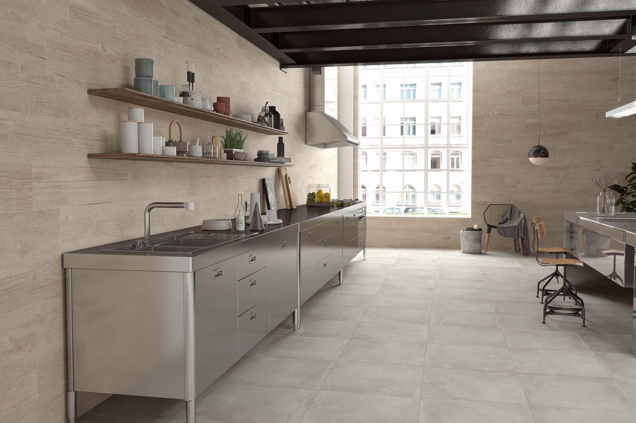 Cuisine lumineuse avec évier en acier inoxydable, étagères en bois et carrelage imitation bois
