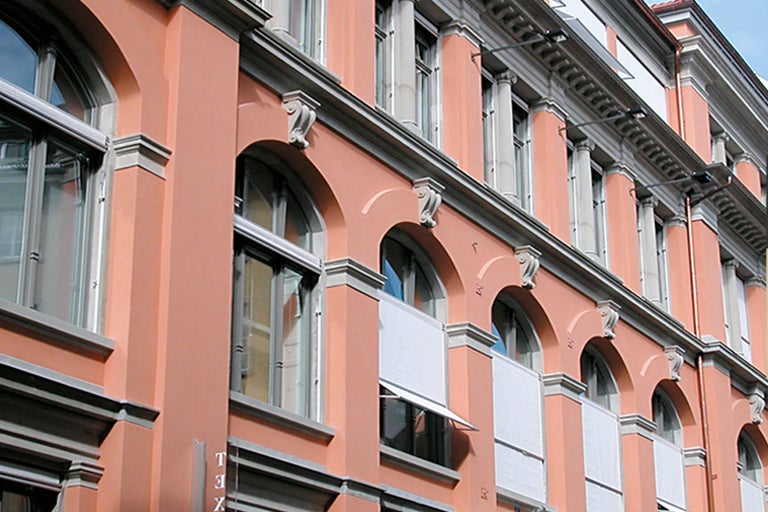 Fassade eines Gebäudes mit Bogenfenstern und Fensterläden