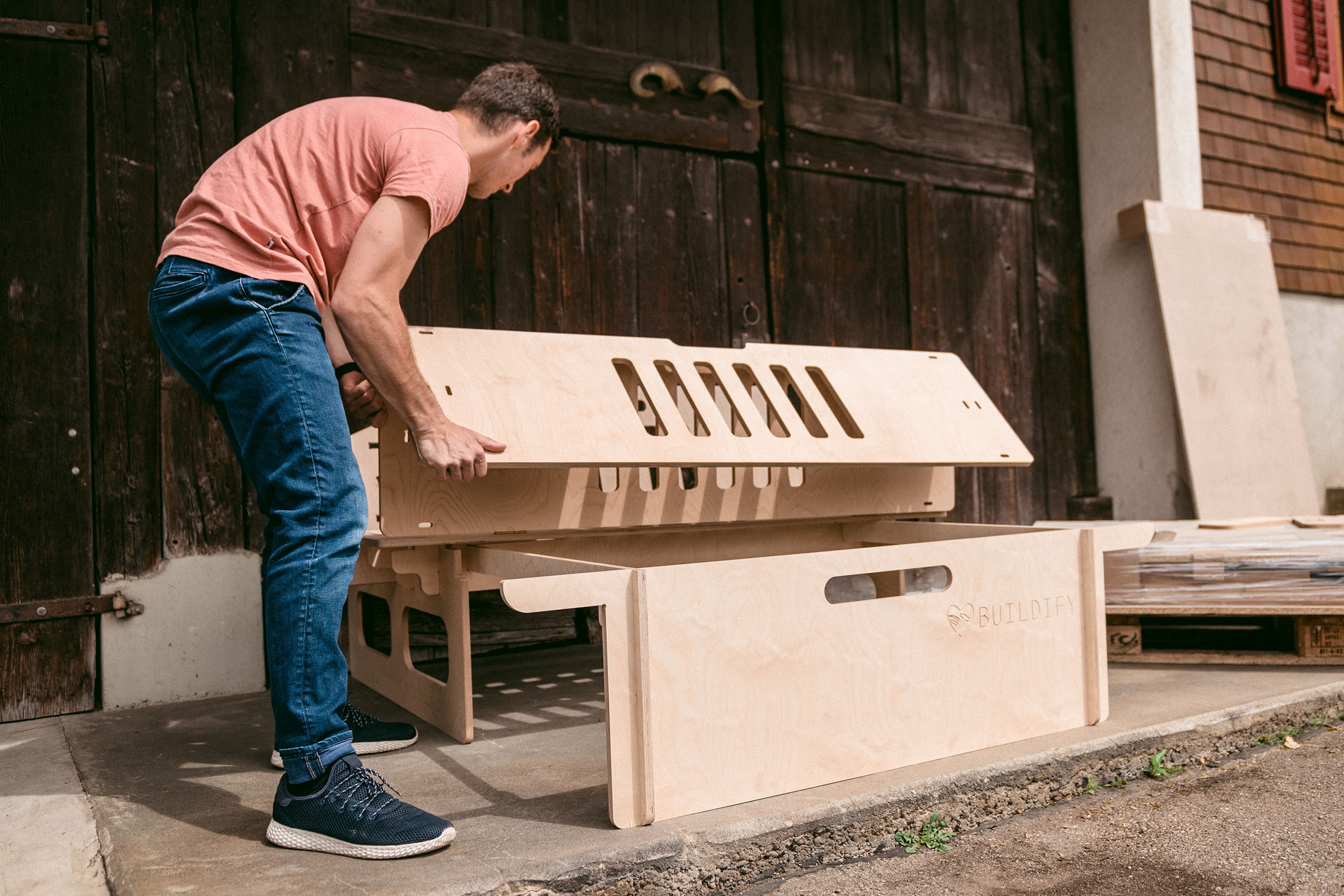 Un homme assemble un kit de construction en bois pour l'extérieur