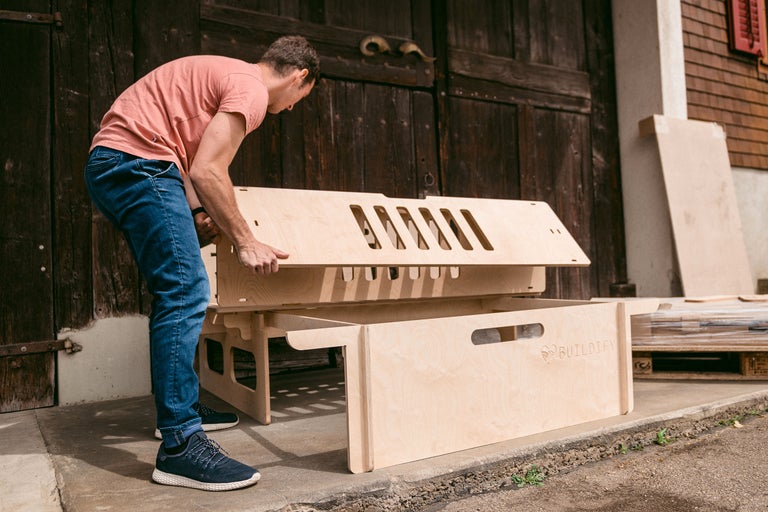 Mann montiert einen Bausatz aus Holz für den Aussenbereich