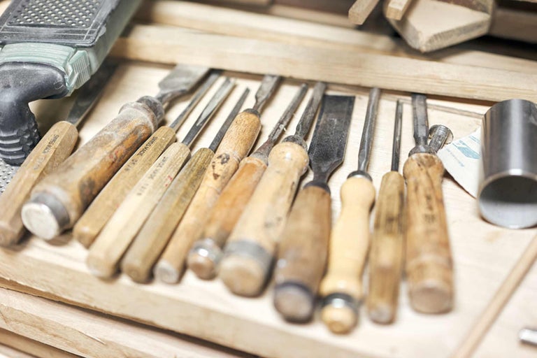 Verschiedene Stecheisen mit Holzgriffen in einer Werkzeugkiste