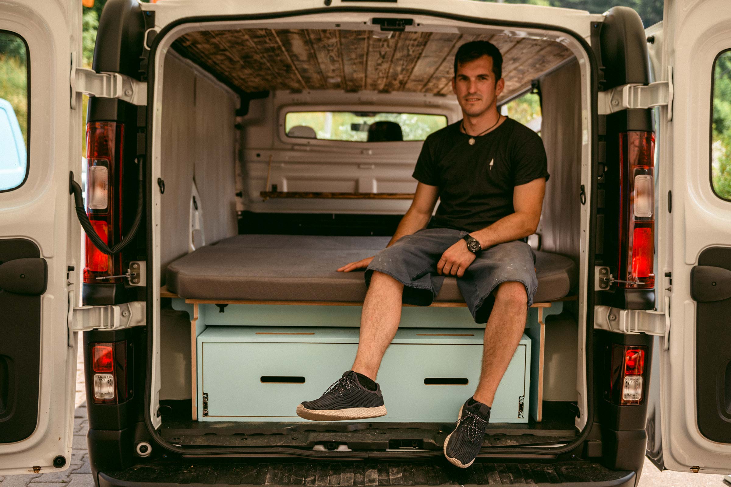 Aménagement intérieur d'un fourgon avec lit et espace de rangement