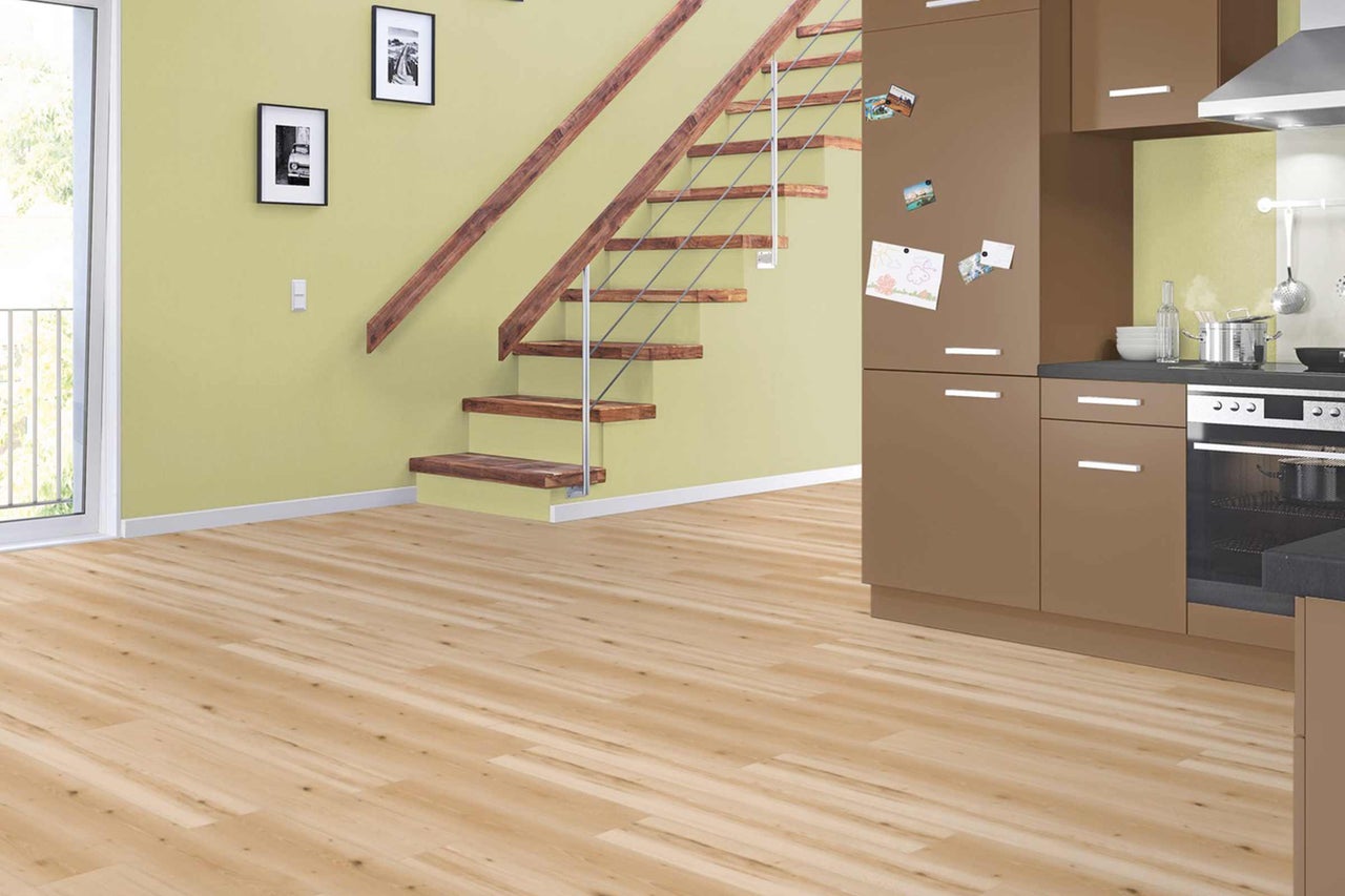 Heller Raum mit Holzboden, Treppe und Küchenzeile