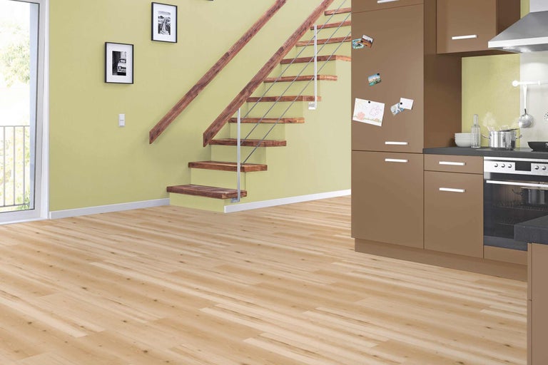 Pièce lumineuse avec plancher en bois, escalier et kitchenette