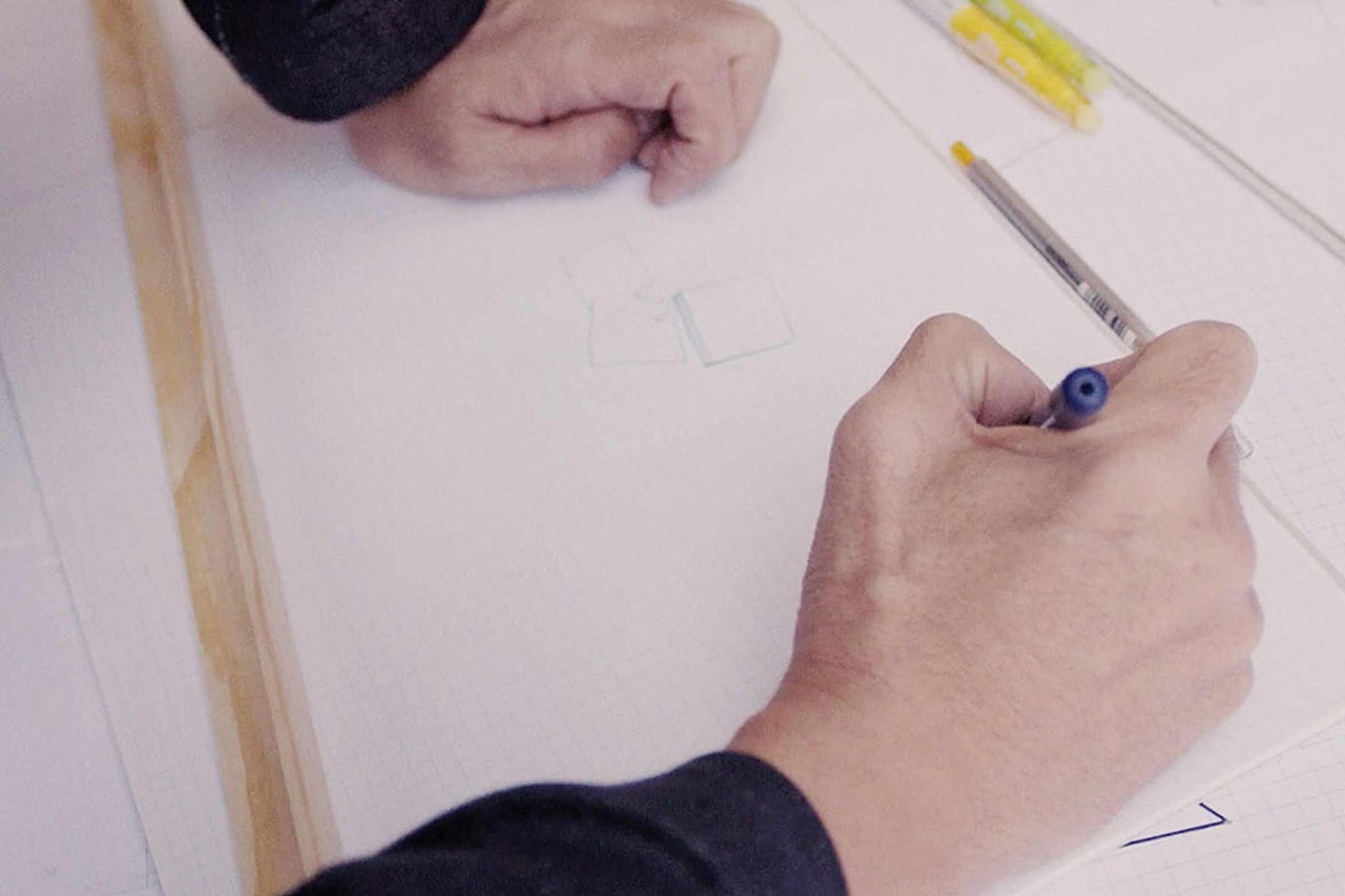 Hand zeichnet Skizze auf ein Blatt Papier