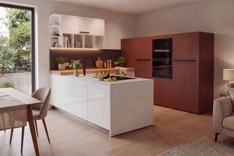 Cuisine moderne avec îlot central, façades blanches, bloc d armoires sombre, plan de travail en bois et coin repas intégré dans un plan ouvert.