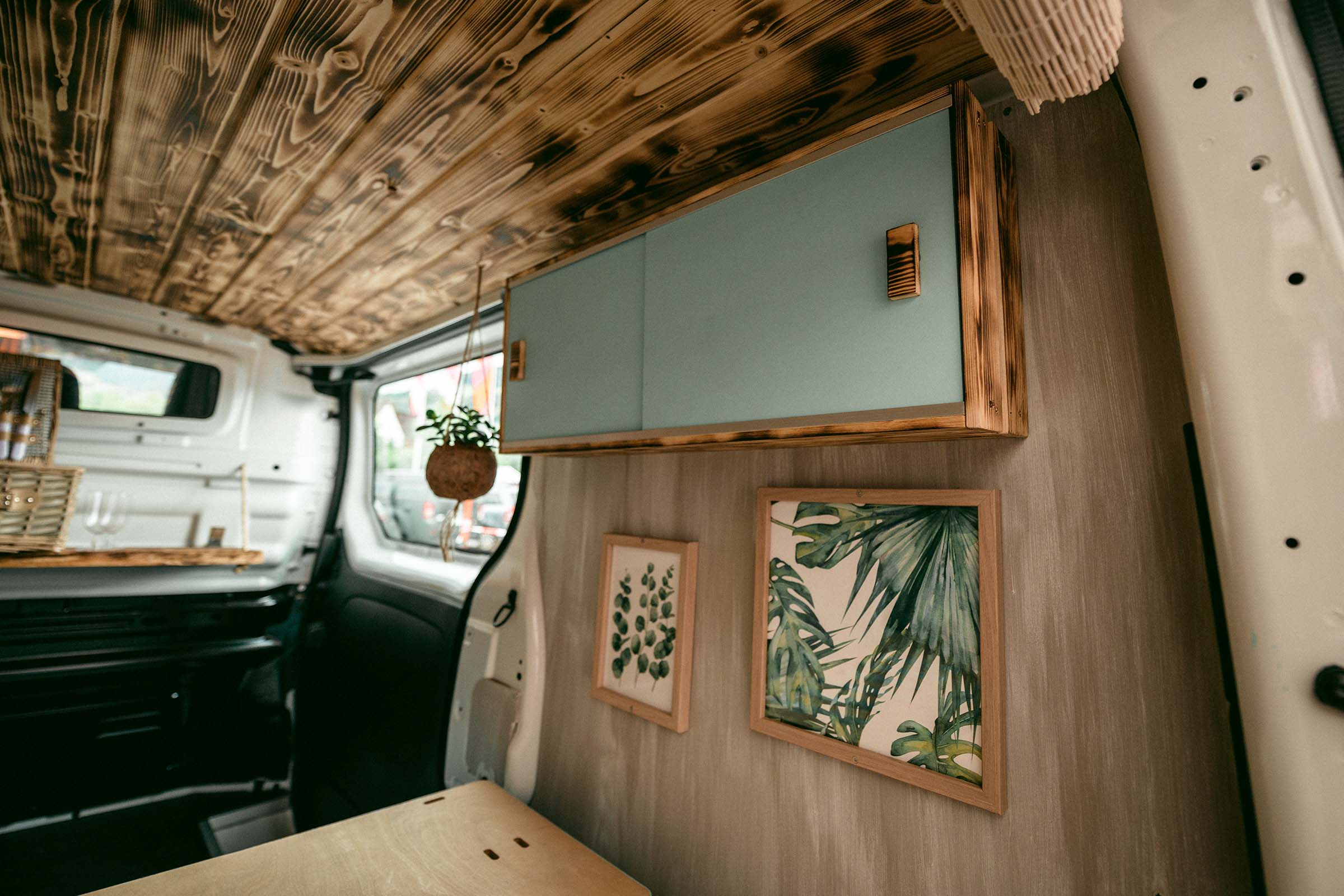 Aménagement intérieur d'un camping-car avec plafond en bois, armoire et décoration