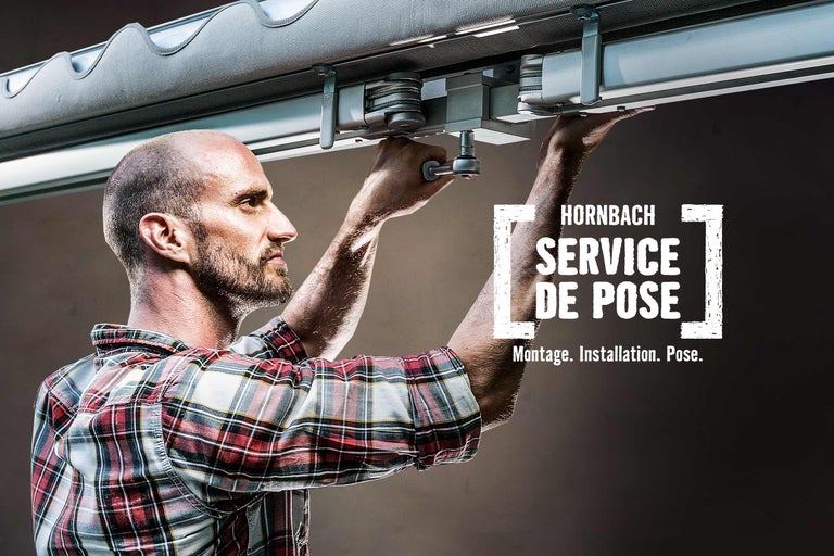 Un homme installe un store banne. Service de montage Hornbach.