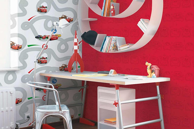 Chambre d'enfant avec bureau, chaise et étagères devant des papiers peints avec des motifs de voitures et de rues