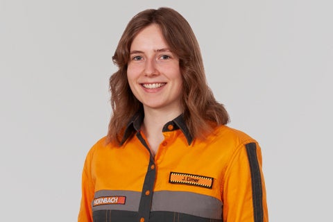 Portrait d'une employée Hornbach souriante en vêtements de travail.