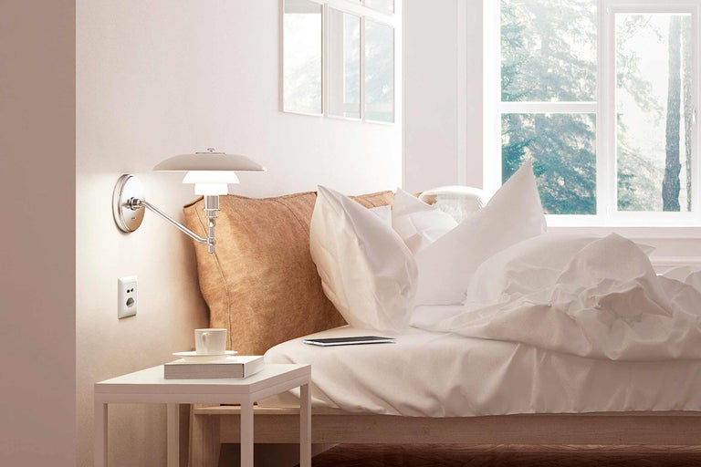 Chambre claire avec lit, table de chevet et applique murale