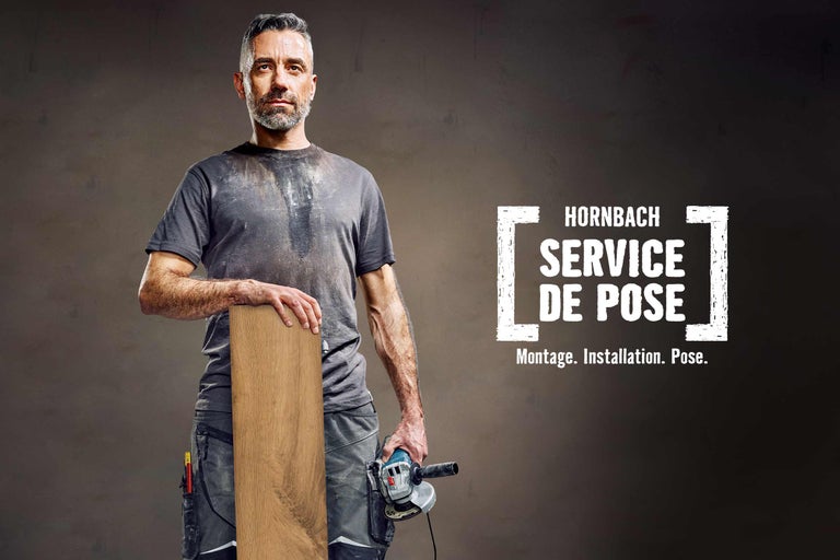 Un homme tenant une planche de bois et une meuleuse d'angle. Service de pose Hornbach