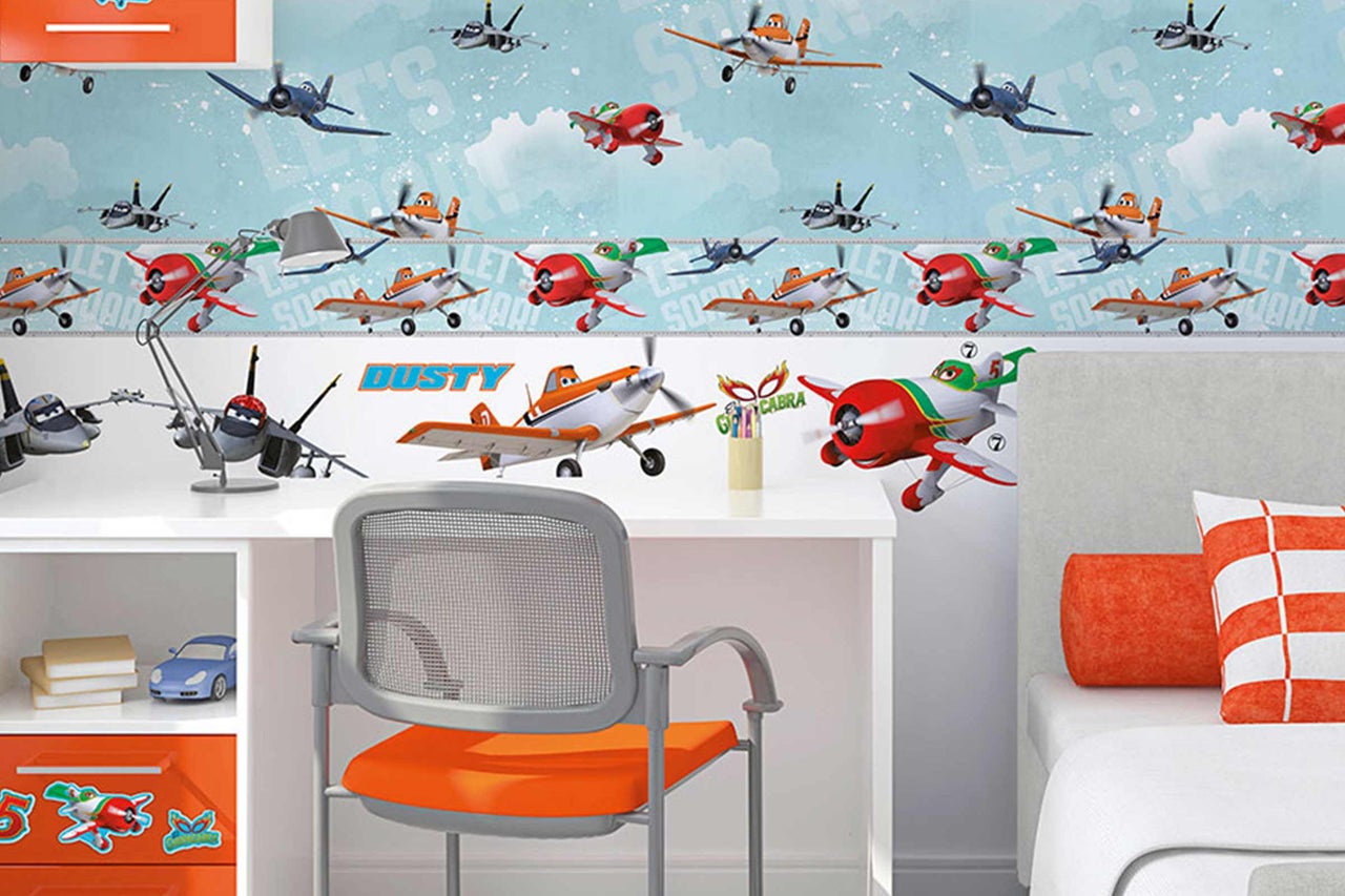 Chambre d'enfant avec papier peint à motifs d'avions et bureau