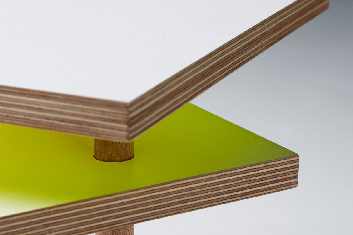 Detailansicht eines Möbelstücks mit Tischplatten aus beschichtetem Holz und einem Holzbein