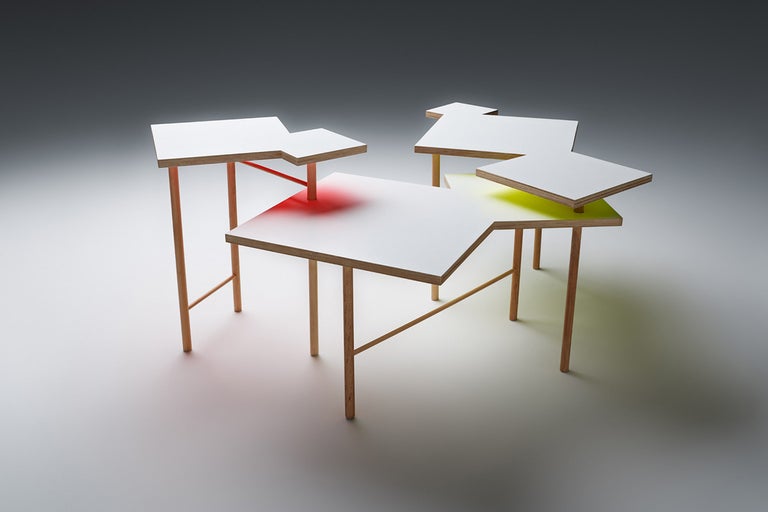 Plusieurs tables d'appoint en bois et plateaux de table blancs forment un groupe de tables.