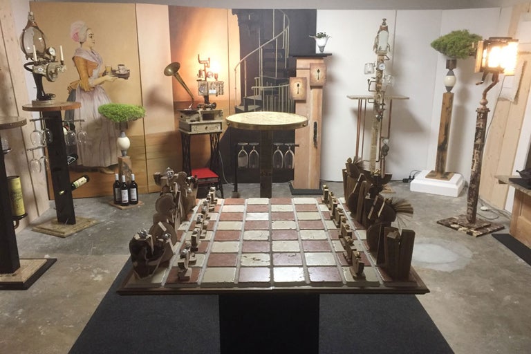 Vue d'intérieur avec échiquier, tables, lampes et œuvres murales