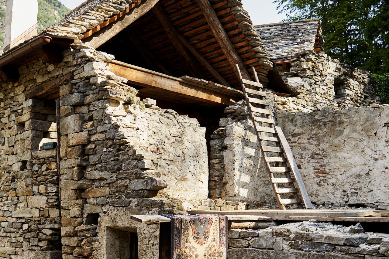 Bâtiment historique avec façade en pierre, structure en bois et échelle