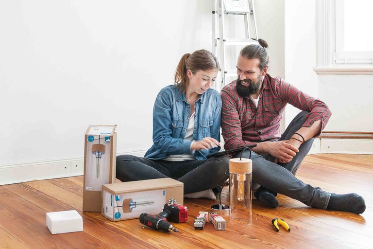 Un couple planifie une rénovation d'espace de vie avec des outils et une lampe
