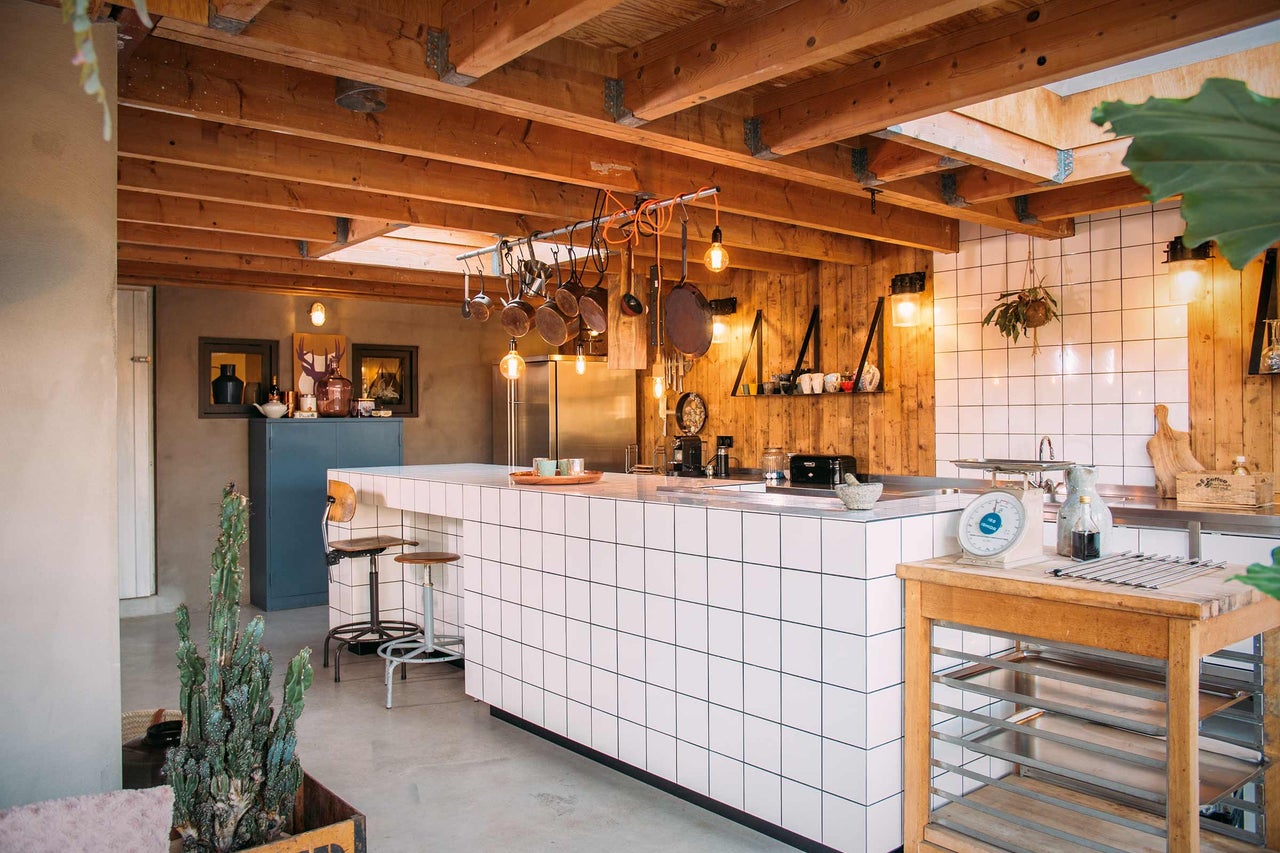 Cuisine claire avec éléments en bois et îlot de cuisine avec revêtement en carrelage.