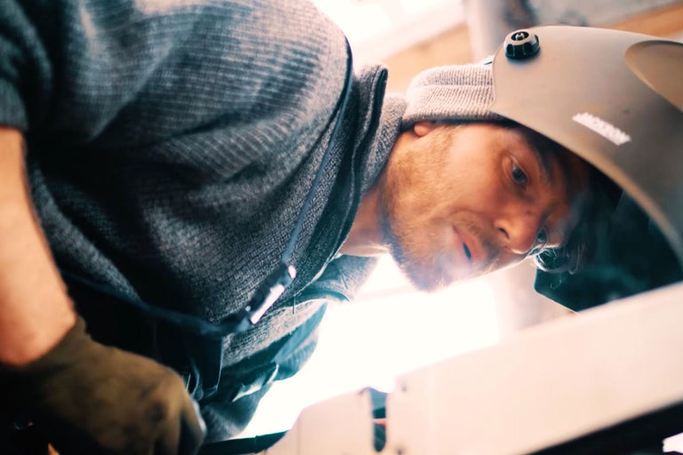 Un homme avec un casque de soudure au travail