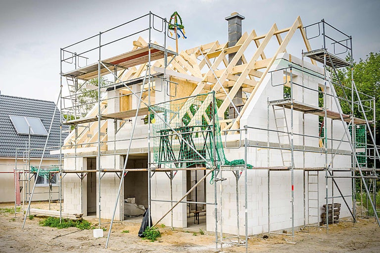 Gros œuvre d'une maison avec échafaudage et bouquet de chantier