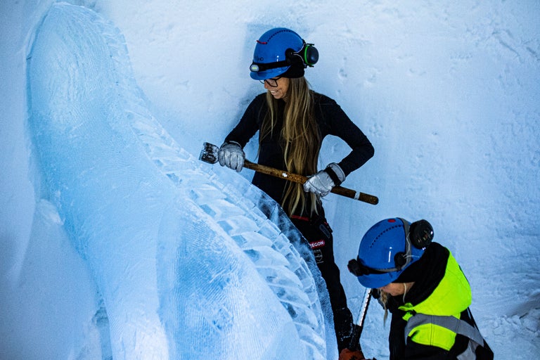 Alpinistes sur glace avec casque, gants et piolet travaillant sur une paroi de glace