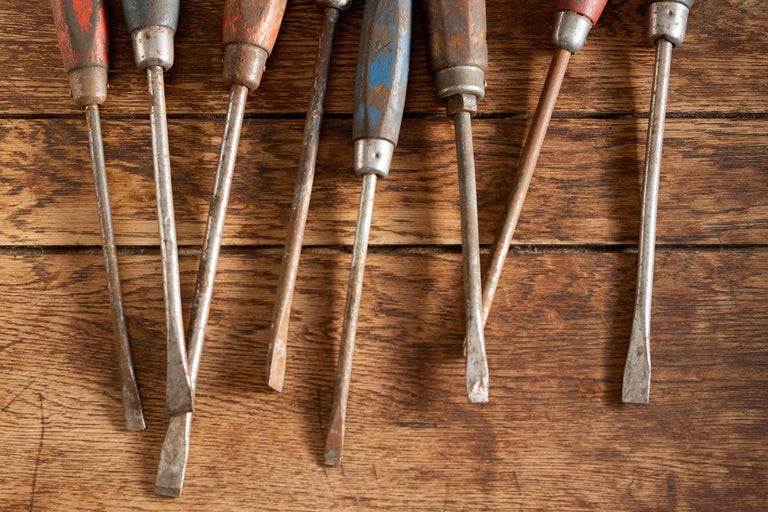 Plusieurs tournevis avec manche en bois sur une table en bois