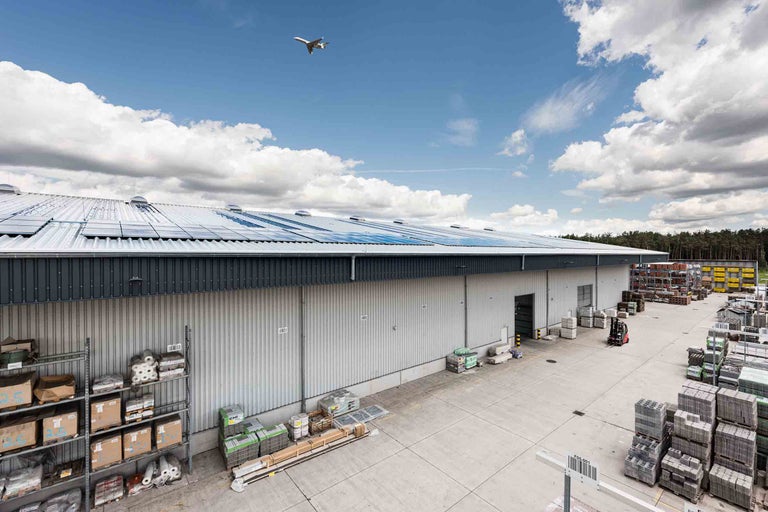 Vue extérieure d'un magasin de bricolage Hornbach avec des panneaux solaires sur le toit et des zones de stockage