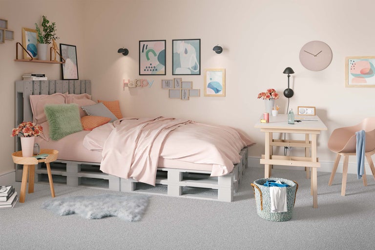 Chambre lumineuse avec lit en palettes, bureau et décoration