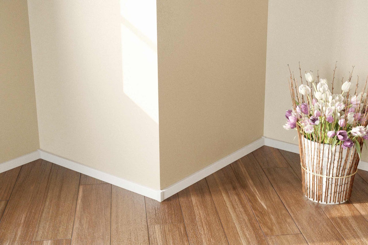 Raumecke mit Sockelleisten, Holzboden und Blumenarrangement