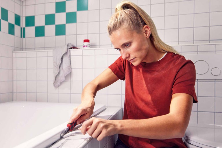 Nettoyage d'une plinthe avec un couteau à mastic et un chiffon