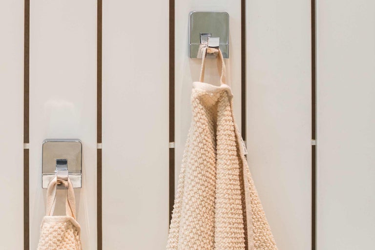 Serviettes sur des crochets chromés sur un mur