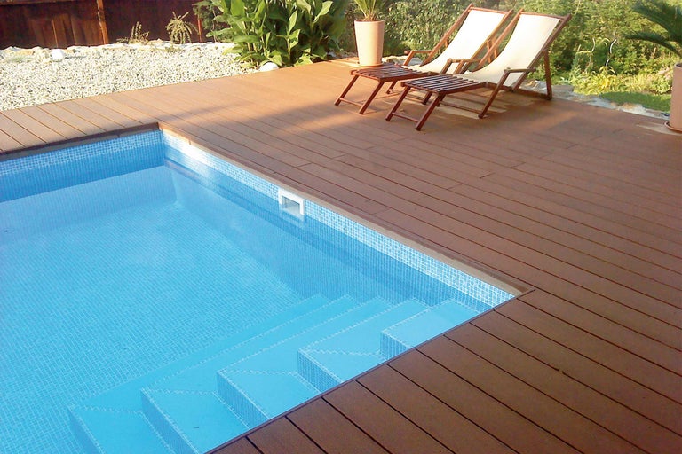 Piscine avec mosaïque et terrasse en bois avec chaises longues