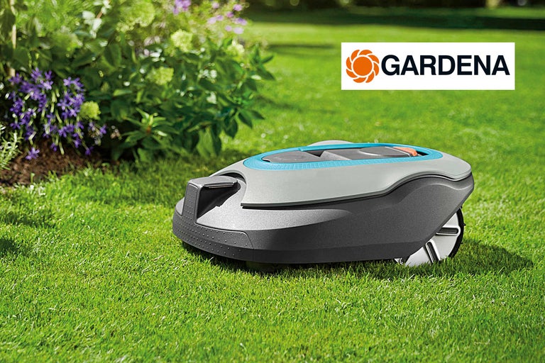Robot tondeuse Gardena sur une pelouse avec des buissons et des fleurs en arrière-plan, logo Gardena.