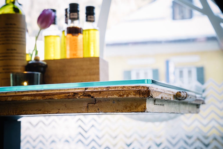 Dekoratives Arrangement mit Glasplatte, Ölen und einer Tulpe