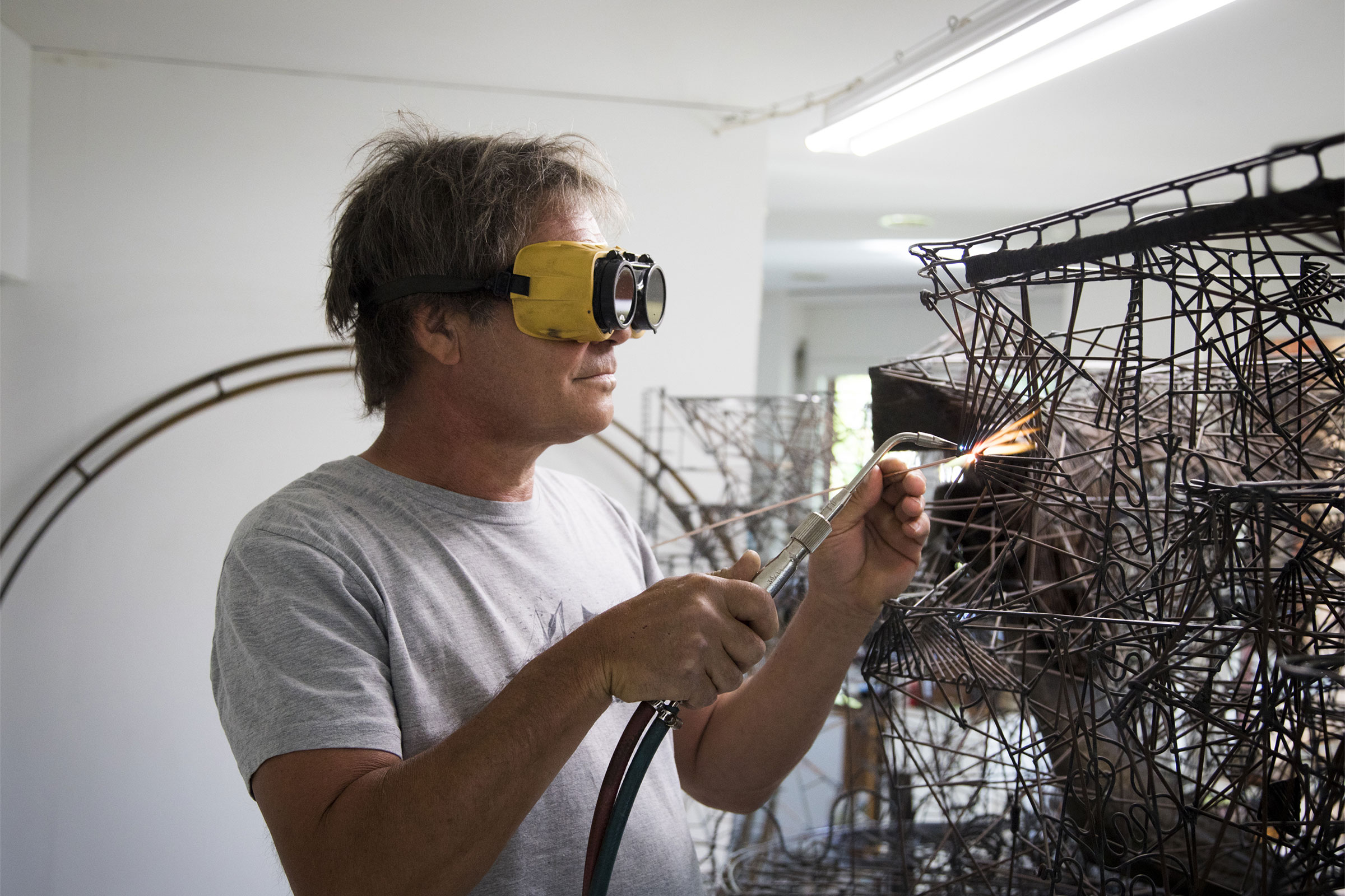 Homme avec lunettes de soudure soudant une structure métallique