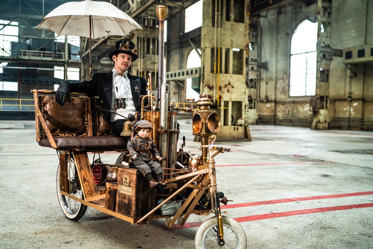 Homme en costume steampunk sur un tricycle décoré