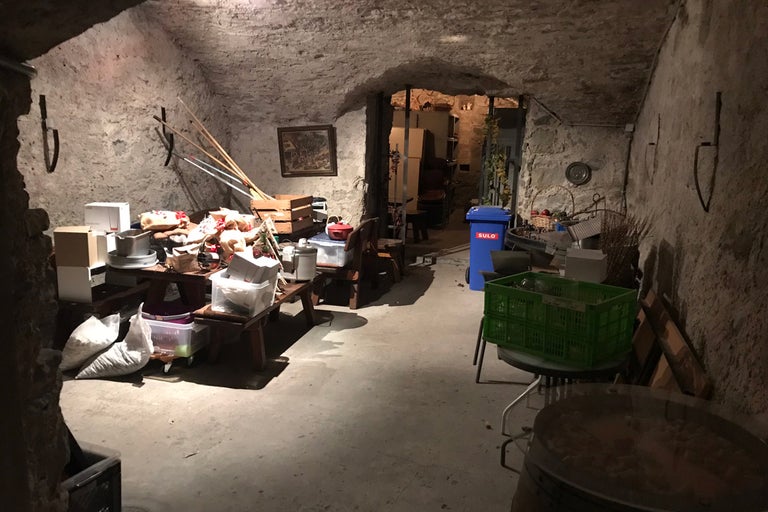 Cave avec des objets tels que des tables, des caisses et une poubelle