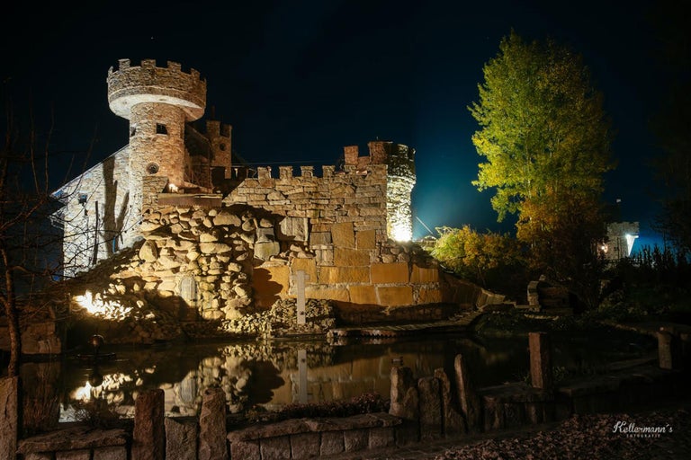 Château en pierre avec étang de nuit