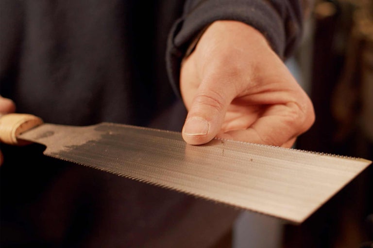 Gros plan d'une scie à main avec manche en bois