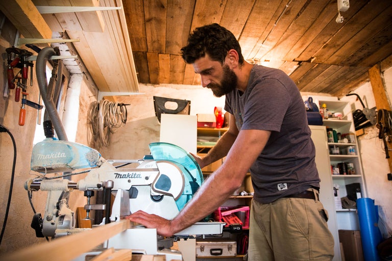 Ein Mann arbeitet mit einer Makita Kapp- und Gehrungssäge in einer Werkstatt.