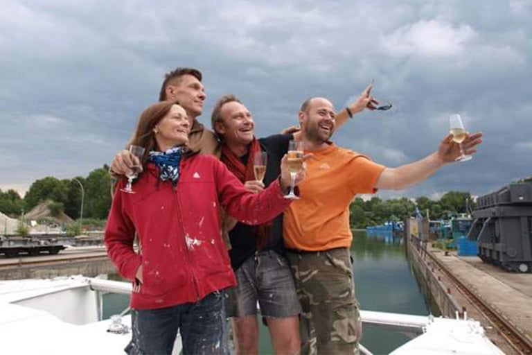 Quatre personnes avec des coupes de champagne sur un bateau, célébrant peut-être un événement