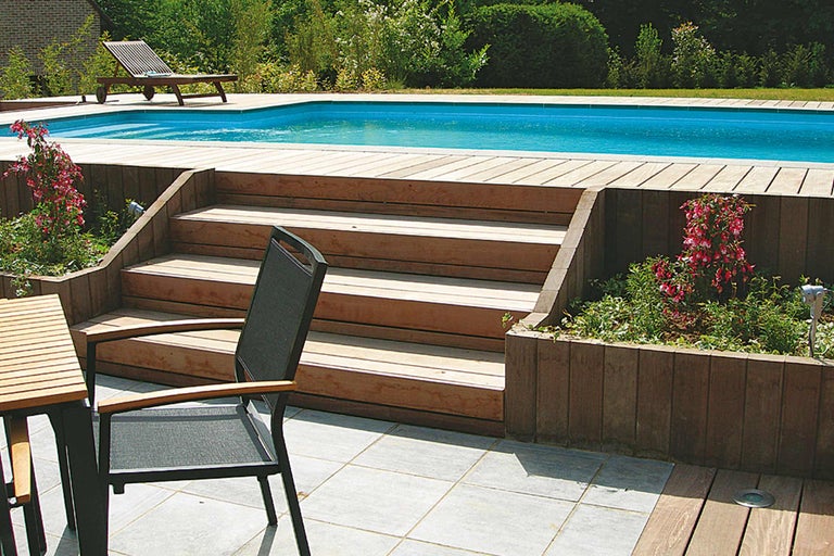 Piscine avec terrasse en bois, escalier et mobilier de jardin