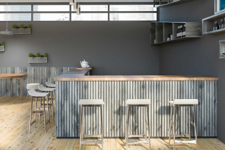 Photo d'intérieur d'un bar avec des éléments en bois et des tabourets de bar