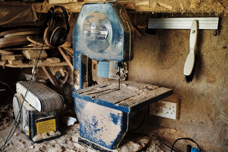 Atelier avec scie à ruban, ponceuse, protection auditive et outils