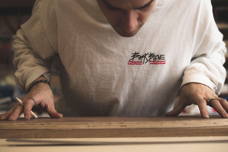 Eine Person arbeitet mit Holz und einem Bleistift.