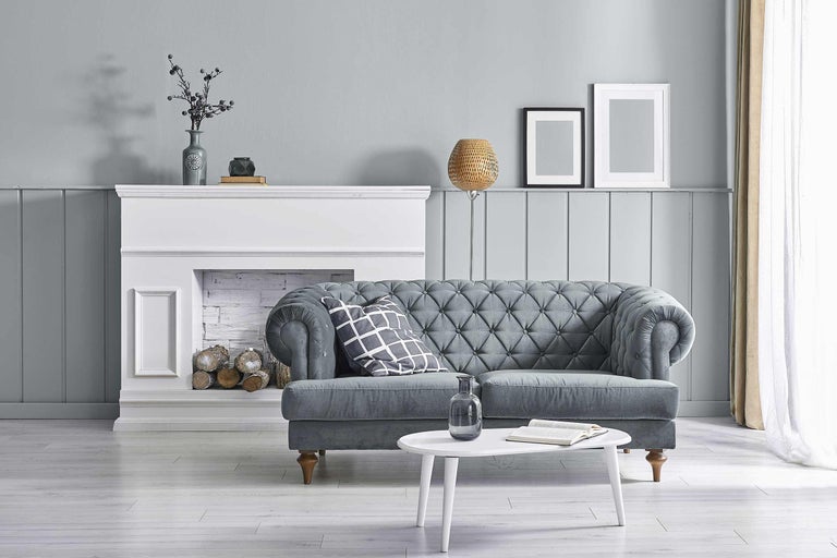 Wohnzimmer-Szene mit grauem Sofa, weißem Kamin und rundem Tisch