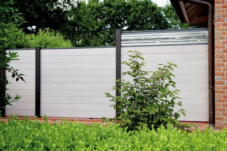 Aussenansicht eines Gartenzauns mit horizontalen Elementen und dunkelbraunen Pfosten